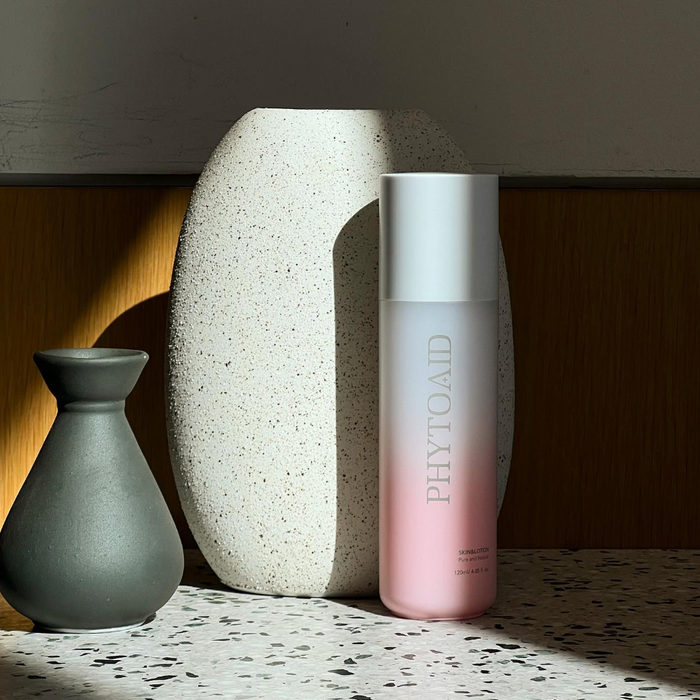 Phytoaid Plus Skin & Lotion bottles on white surface with goji berry and apple fruit accents. Beautifulsmile cosmetics UK