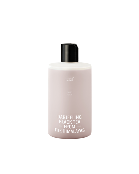 Luxury body wash enriched with Darjeeling black tea extract, photographed with tea leaves and gentle foam to highlight its silky-skin benefits.