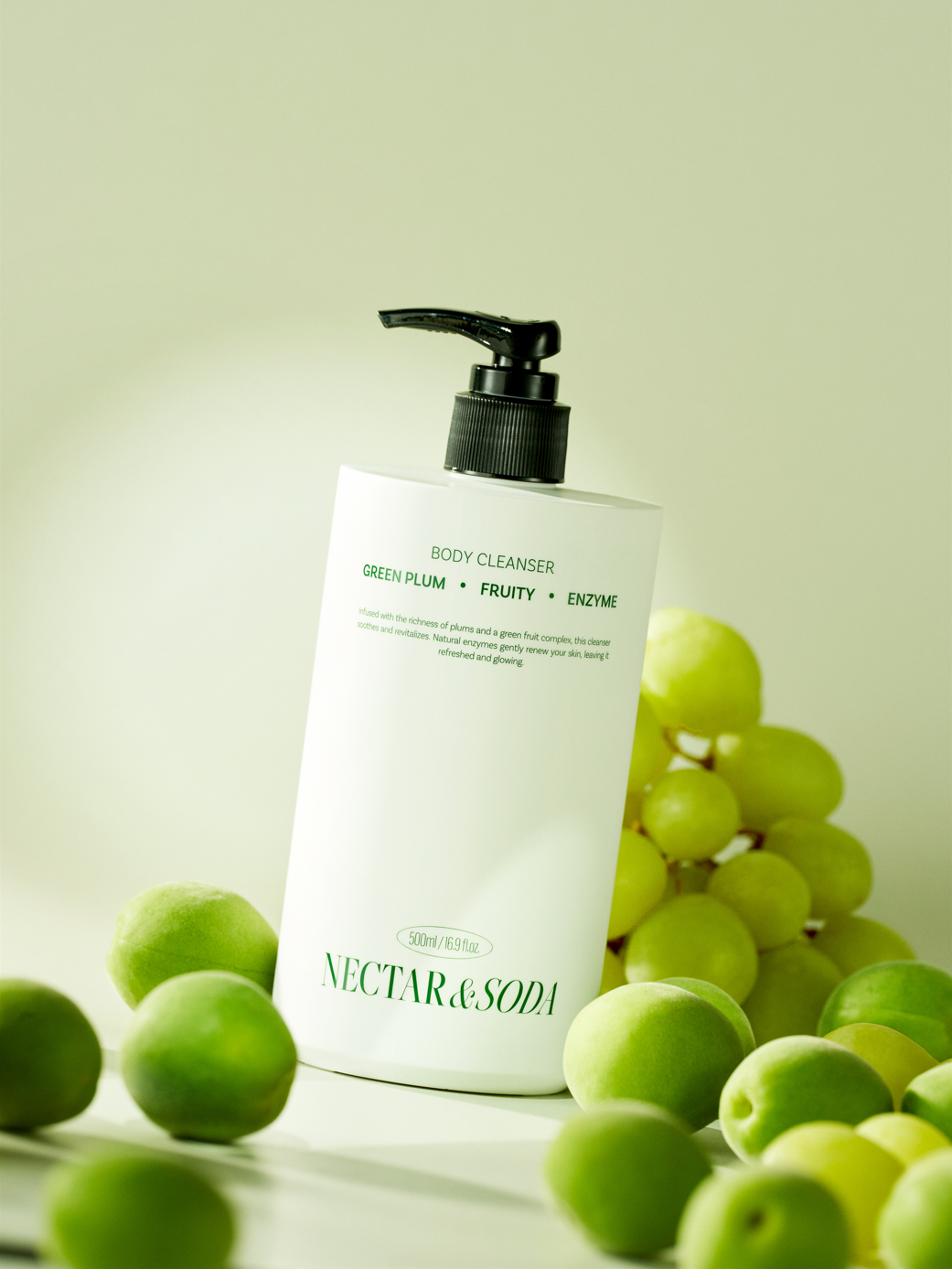 Image of a hand dispensing a clear, gel-like texture of the Green Plum Fruit Enzyme Body Cleanser, showing rich lather on wet skin.