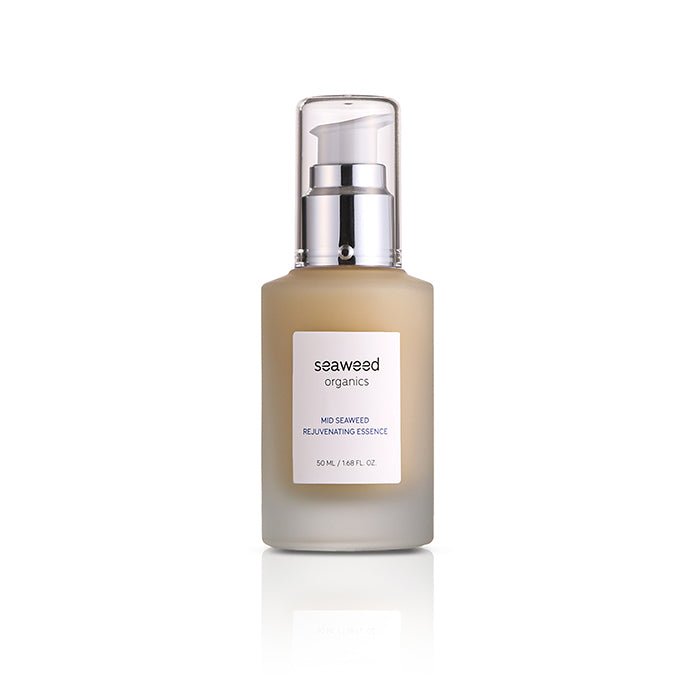 Mid Seaweed Rejuvenating Essence in a glass pump bottle surrounded by wild sea botanicals