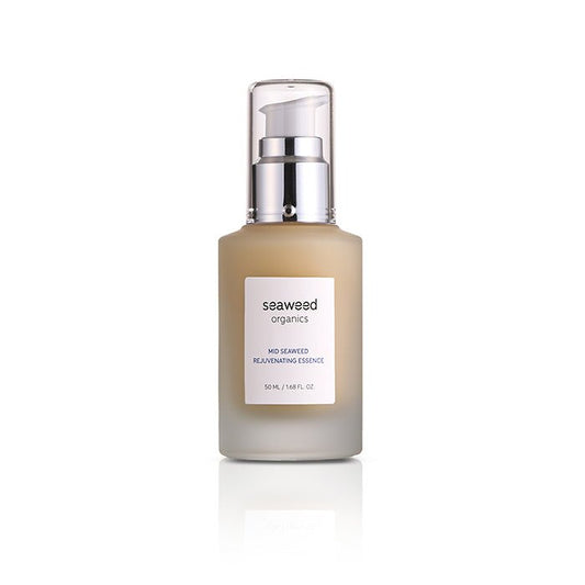 Mid Seaweed Rejuvenating Essence in a glass pump bottle surrounded by wild sea botanicals