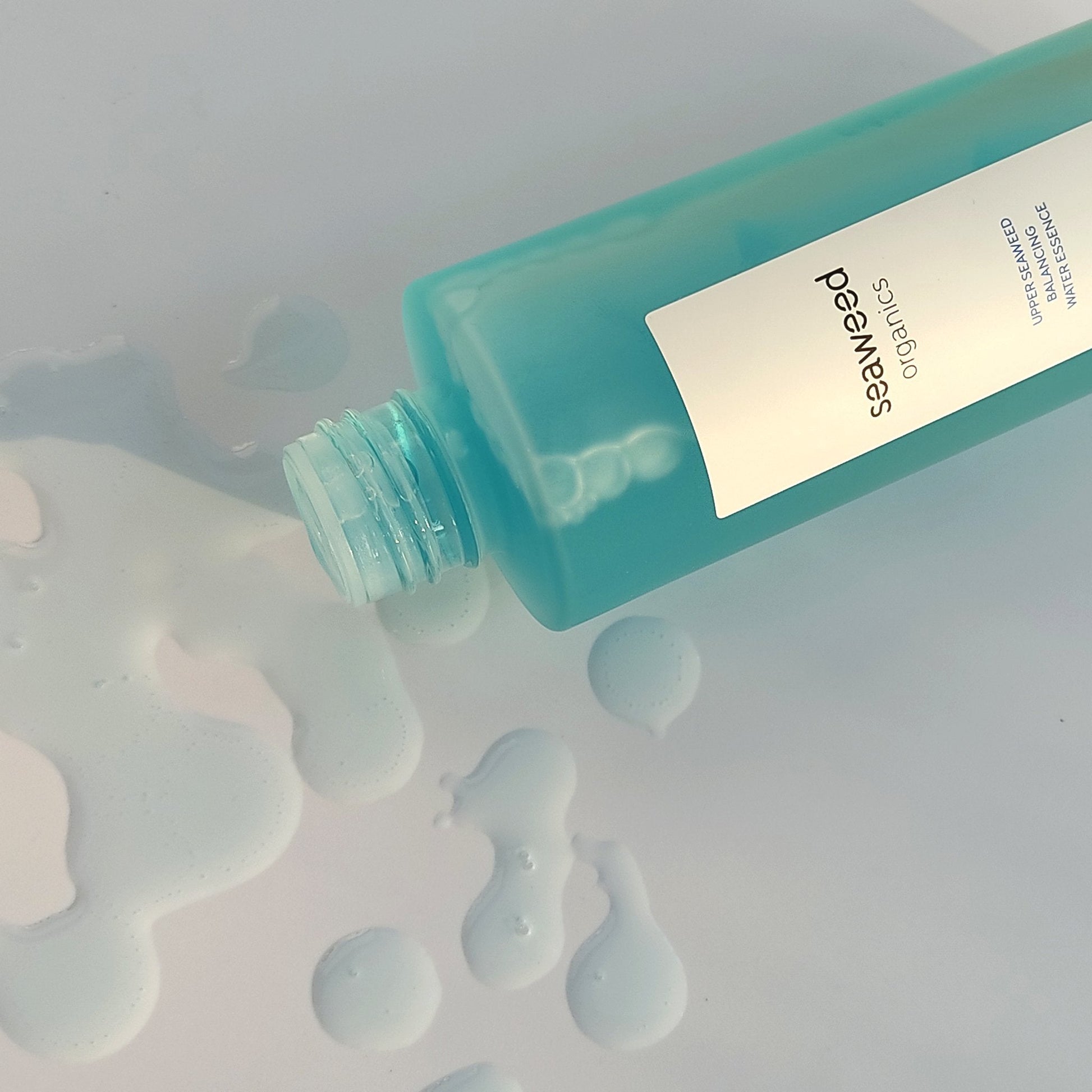 Top-down view of hydrating seaweed essence on linen with wild herbs