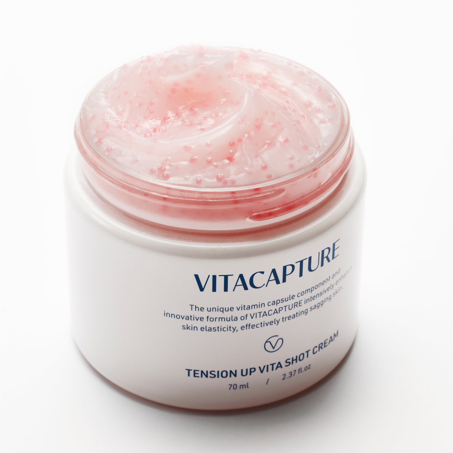 A person applying Tension Up Vita Shot Cream to their face, highlighting the visible effects of tightened, nourished, and moisturized skin, suggesting a glowing, healthier complexion.